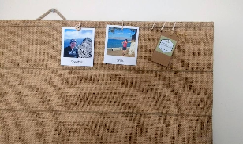 Puede incluir: Un tablero de anuncios de arpillera con tres fotos y una etiqueta fijada a &eacute;l. Las fotos son de una persona en Snowdonia y una persona en Creta. La etiqueta dice "Handmade with love for MODERN EAT".