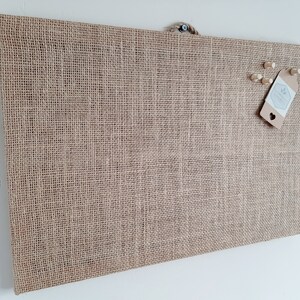 cork board covered in hessian fabric.