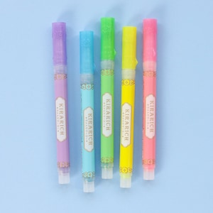 May include: Five colorful highlighter pens with a gold label that reads "KIRARICH" in a decorative font. The pens are arranged in a row from left to right: purple, blue, green, yellow, and pink.