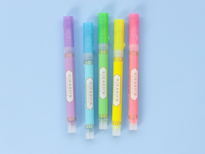 May include: Five colorful highlighter pens with a gold label that reads "KIRARICH" in a decorative font. The pens are arranged in a row from left to right: purple, blue, green, yellow, and pink.