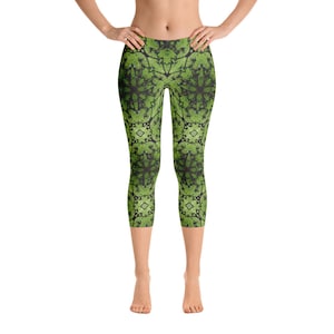 May include: Green and black patterned leggings with a geometric design. The leggings are cropped and have a fitted silhouette.