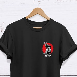 May include: Black t-shirt with a white graphic of a samurai warrior standing in front of a red sun.