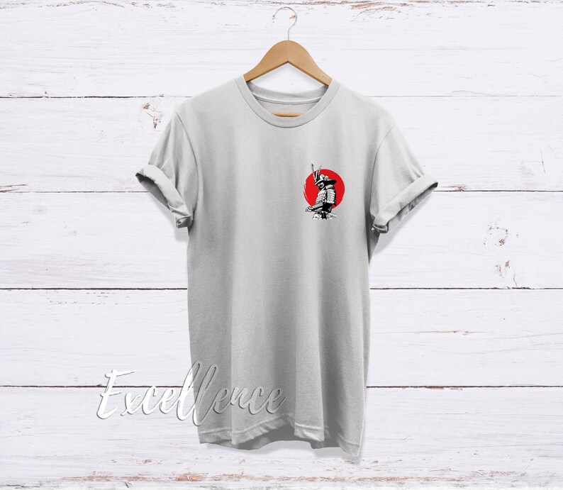 May include: A gray t-shirt with a black and white illustration of a samurai warrior standing in front of a red sun.