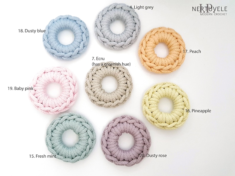 K&ouml;nnte beinhalten: Zehn geh&auml;kelte Ringe in verschiedenen Farben, darunter staubiges Blau, Babyrosa, Hellgrau, Ecru, Frischminze, Staubiges Rosa, Pfirsich und Ananas. Die Ringe sind in einem Kreis auf wei&szlig;em Hintergrund angeordnet.