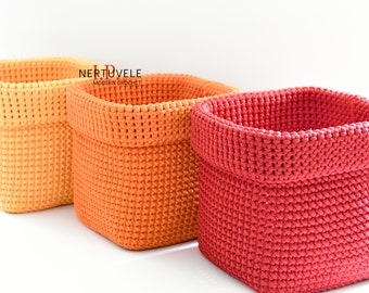 May include: Three crocheted storage baskets in different sizes. The baskets are square shaped and made with a textured stitch. The colors are yellow, orange, and red.