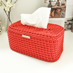 Op de afbeelding: Rode gehaakte tissuebox met een houten label met de tekst "Als je het kunt dromen".