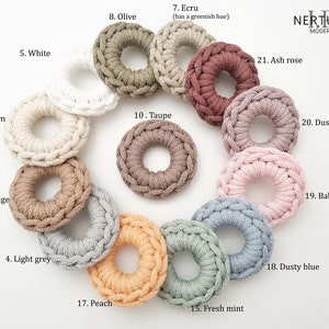 Puede incluir: Una colecci&oacute;n de 21 anillos de crochet en varios colores, incluyendo blanco, crema, beige, gris claro, oliva, crudo, topo, melocot&oacute;n, menta fresca, azul polvoriento, rosa beb&eacute;, rosa polvoriento y rosa ceniza. Los anillos est&aacute;n dispuestos en un c&iacute;rculo sobre un fondo blanco.
