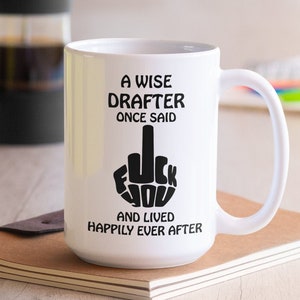 May include: White coffee mug with a black graphic of a middle finger and the text "A wise drafter once said... and lived happily ever after".