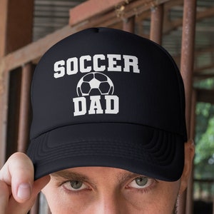 May include: Black trucker hat with a white soccer ball and the text "Soccer Dad" on the front.