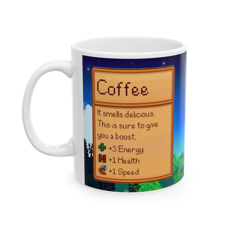May include: White ceramic mug with a colorful image of a video game-style coffee item. The image features a brown wooden sign with the text "Coffee" and a description of the item's effects: "It smells delicious. This is sure to give you a boost. +3 Energy +1 Health +1 Speed".