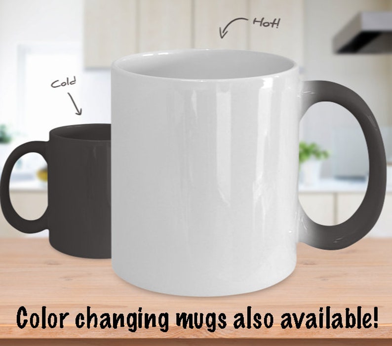 K&ouml;nnte beinhalten: Eine wei&szlig;e Keramiktasse mit schwarzem Henkel. Die Tasse wechselt die Farbe, wenn sie hei&szlig; ist, und wird schwarz. Die Tasse steht auf einer Holzoberfl&auml;che. "Hei&szlig;!" und "Kalt" sind auf dem Bild geschrieben.