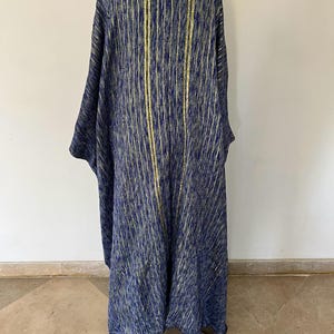 Op de afbeelding: Een lange, blauw-gouden gestreepte robe met een V-hals. De robe is gemaakt van een zachte, textuurrijke stof. #24