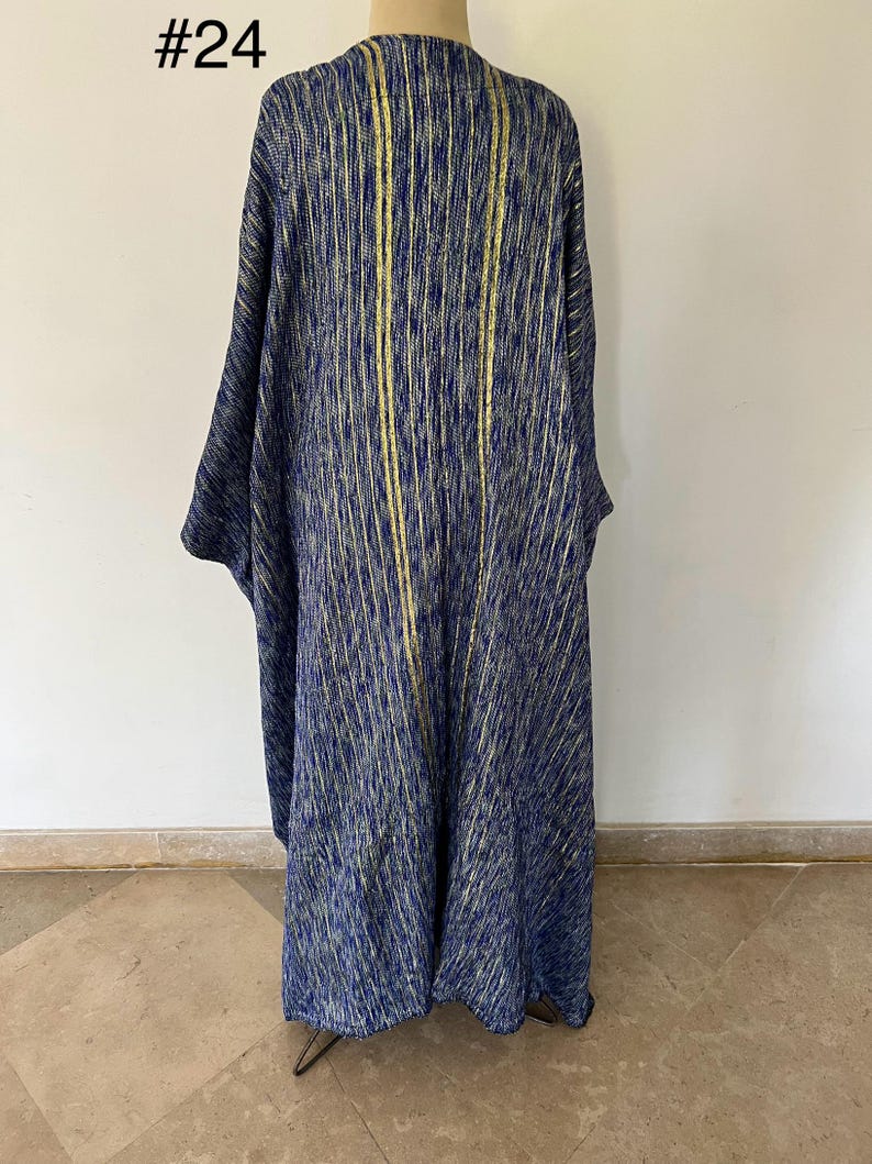 Op de afbeelding: Een lange, blauw-gouden gestreepte robe met een V-hals. De robe is gemaakt van een zachte, textuurrijke stof. #24