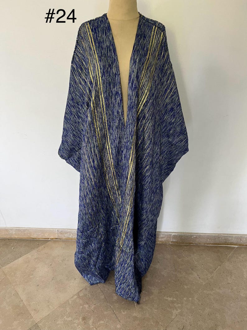 Op de afbeelding: Een lange, marineblauwe en gouden kimono met een V-hals en een losse pasvorm. De kimono heeft een textuur met gouden strepen.