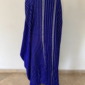 Op de afbeelding: Een lange, blauwe robe met zilveren strepen. De robe is gemaakt van een zachte, vloeiende stof en heeft een ontspannen pasvorm.
