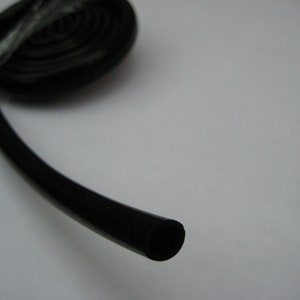 May include: A black rubber seal or gasket, rolled up and ready to be used.