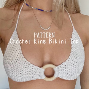 Puede incluir: Top de bikini de crochet blanco con un detalle de anillo de madera. El patrón se llama "Crochet Ring Bikini Top".