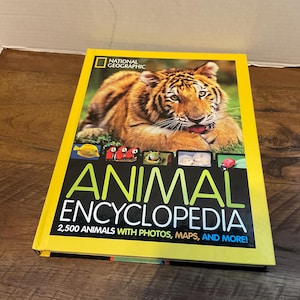 May include: A National Geographic Animal Encyclopedia book with a yellow cover. The cover features a tiger and the title "ANIMAL ENCYCLOPEDIA" in large, bold letters. The book promises 2,500 animals with photos, maps, and more.