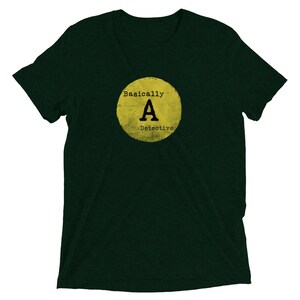 May include: A dark green t-shirt with a yellow circle graphic that says "Basically A Detective" in black text.