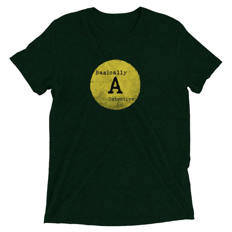 May include: A dark green t-shirt with a yellow circle graphic that says "Basically A Detective" in black text.