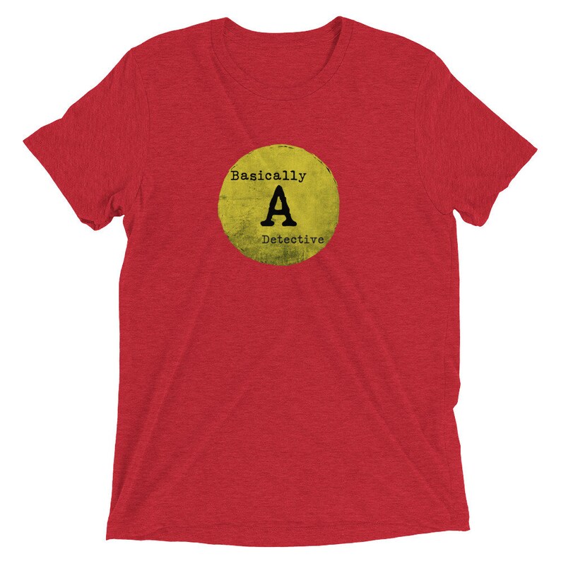 May include: Red short-sleeved t-shirt with a yellow circle graphic that says "Basically A Detective" in black text.