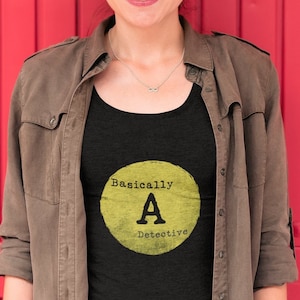 May include: A black tank top with a yellow circle graphic that says "Basically A Detective".