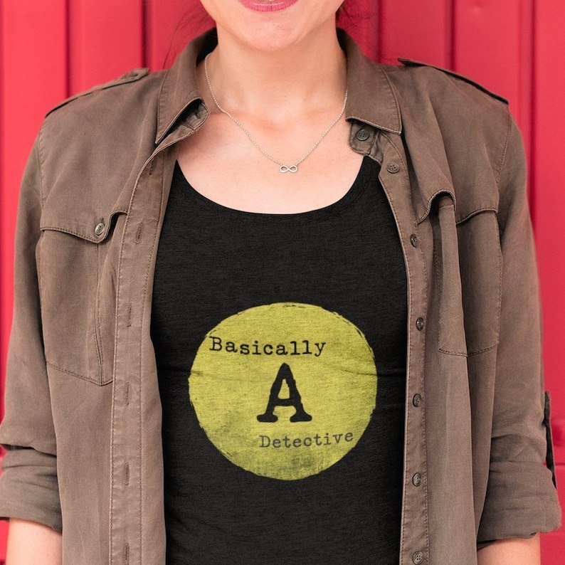 May include: A black tank top with a yellow circle graphic that says "Basically A Detective".