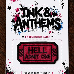 May include: A rectangular embroidered patch featuring a dark red ticket design with a black border. The text HELL ADMIT ONE is centred in black, with the number 666 on both sides. The patch is mounted on a white display card with black and blue ink splatters.
