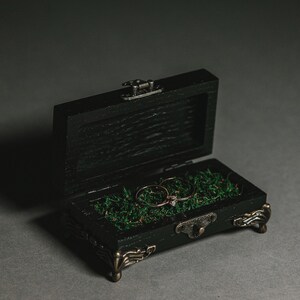 Expertly handcrafted from high-quality wood and finished in an elegant black stain, this ring holder is the perfect accessory for couples seeking a stylish and refined touch
