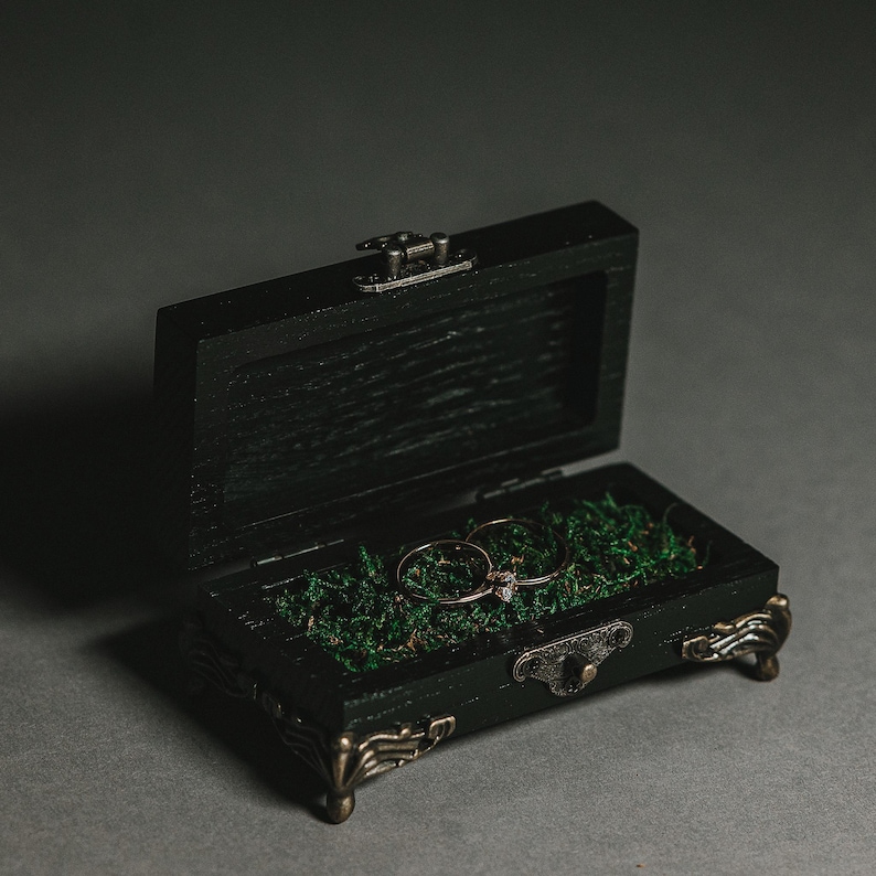 Expertly handcrafted from high-quality wood and finished in an elegant black stain, this ring holder is the perfect accessory for couples seeking a stylish and refined touch