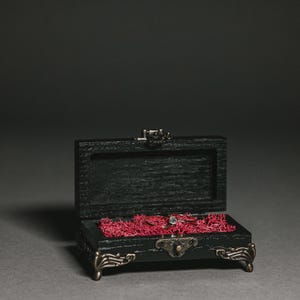 Whether your wedding is in a ballroom, on a beach, or outdoors in a forest or mountains, this black ring box will complement any setting beautifully.