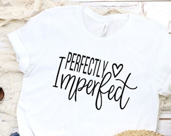 May include: White t-shirt with the text "Perfectly Imperfect" in black lettering with a small heart symbol.