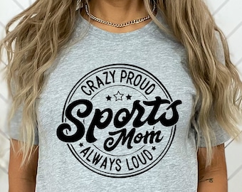 Puede incluir: Camiseta gris con un gráfico circular negro que dice "Crazy Proud Sports Mom Always Loud".
