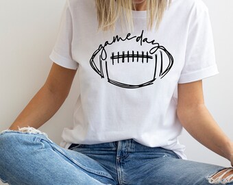 May include: A white t-shirt with a black graphic of a football and the text "game day" on it.