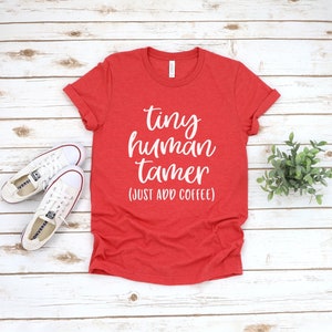 May include: Red t-shirt with white text that reads "tiny human tamer (just add coffee)"