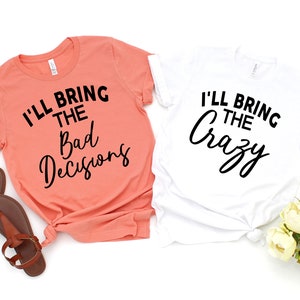 May include: Two t-shirts with a matching design. One is coral pink with the text "I'll bring the bad decisions" and the other is white with the text "I'll bring the crazy".