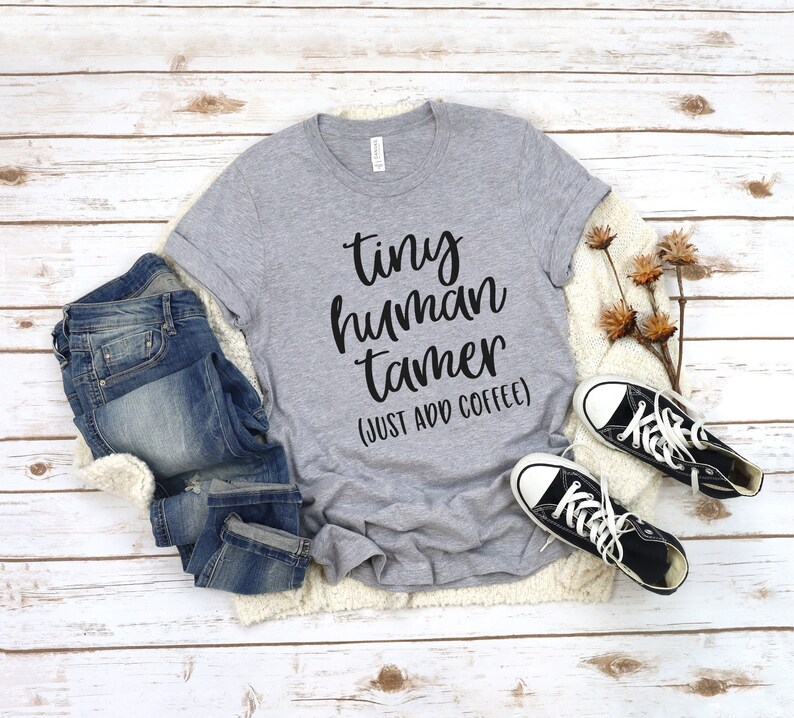 May include: A gray t-shirt with the text "tiny human tamer (just add coffee)" in black lettering.