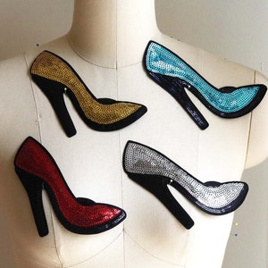 Peut inclure: Quatre patchs de chaussures à talons hauts en sequins de différentes couleurs : or, rouge, argent et bleu. Les patchs sont affichés sur un mannequin blanc.