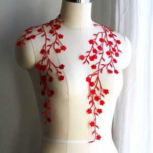Pode incluir: Aplique de renda floral vermelho com detalhes delicados de flores e videiras. Este aplique de renda é perfeito para adicionar um toque de elegância a qualquer peça de roupa ou projeto.