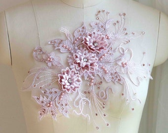Puede incluir: Una delicada aplicación floral de color rosa con adornos de perlas y diamantes de imitación. La aplicación es perfecta para añadir un toque de elegancia a la ropa, los accesorios o la decoración del hogar.