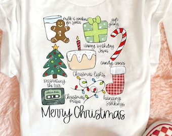 Puede incluir: Camiseta blanca con un gráfico colorido de temática navideña. El diseño incluye un hombre de jengibre, un árbol de Navidad, un pastel, bastones de caramelo y el texto "Merry Christmas."