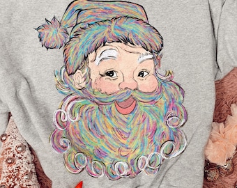 Puede incluir: Una sudadera gris jaspeado de cuello redondo con una ilustración gráfica de Santa Claus. La figura de Santa tiene una barba y un gorro representados en un patrón multicolor, arremolinado y tipo arcoíris con texturas de pinceladas visibles.