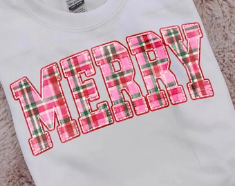 May include: A white long-sleeve sweatshirt featuring the word MERRY in large, block-style letters. The letters have a red, pink, and green plaid pattern with a red stitched outline. The garment has a Gildan brand tag at the inner neckline.
