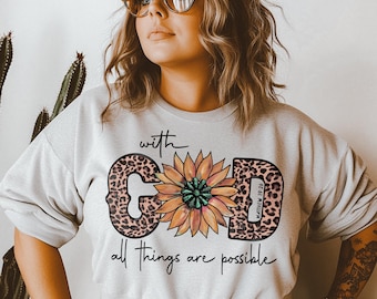May include: A white sweatshirt with a graphic print of a sunflower and the words "with God all things are possible" and "Matthew 19:26".