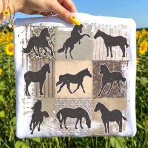 May include: White t-shirt featuring a patchwork design with nine black horse silhouettes. The background squares have various patterns and colors, including floral and striped designs. The shirt is held up in front of a field of sunflowers.
