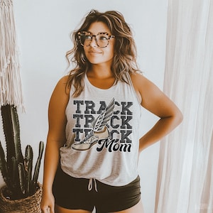 May include: A gray tank top with the words "Track Mom" and a stylized running shoe graphic. The shoe has a white sole and a black wing.