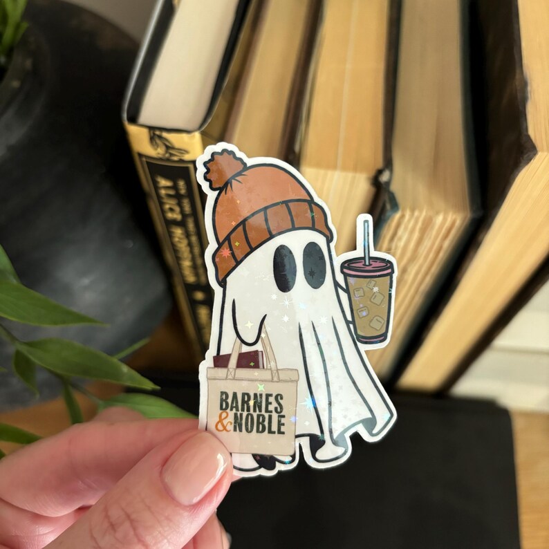 May include: A white ghost wearing an orange and brown beanie hat, holding a brown bag with the text "Barnes & Noble" and a cup of iced coffee.