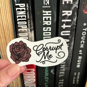 May include: White sticker with a stylized black rose and the text "Corrupt Me" in black cursive lettering.