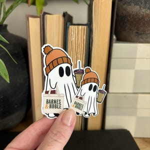 May include: Two white ghost stickers with orange knit hats holding brown coffee cups and Barnes & Noble shopping bags.