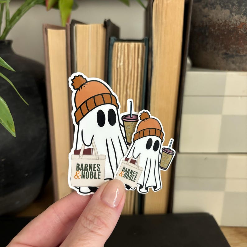 May include: Two white ghost stickers with orange knit hats holding brown coffee cups and Barnes & Noble shopping bags.